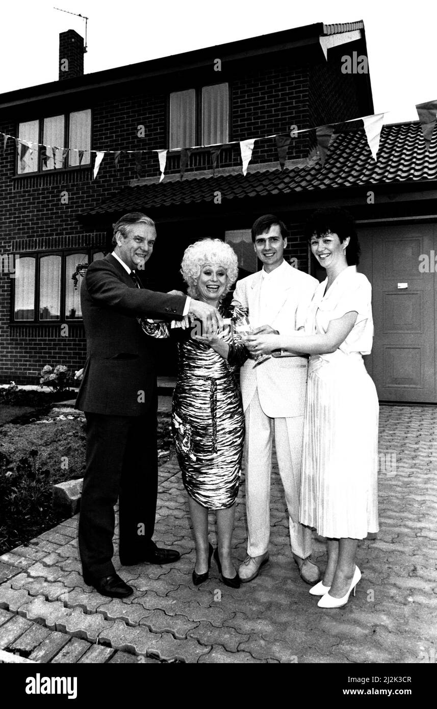 L'attrice Barbara Windsor propone un toast per il riscaldamento della casa ai costruttori di fai da te Allan e Linda Richards 7 giugno 1987. Alan e Linda erano tra una strada piena di persone che hanno costruito le loro case a Chirton Avenue, Marsden in South Shields. Foto Stock