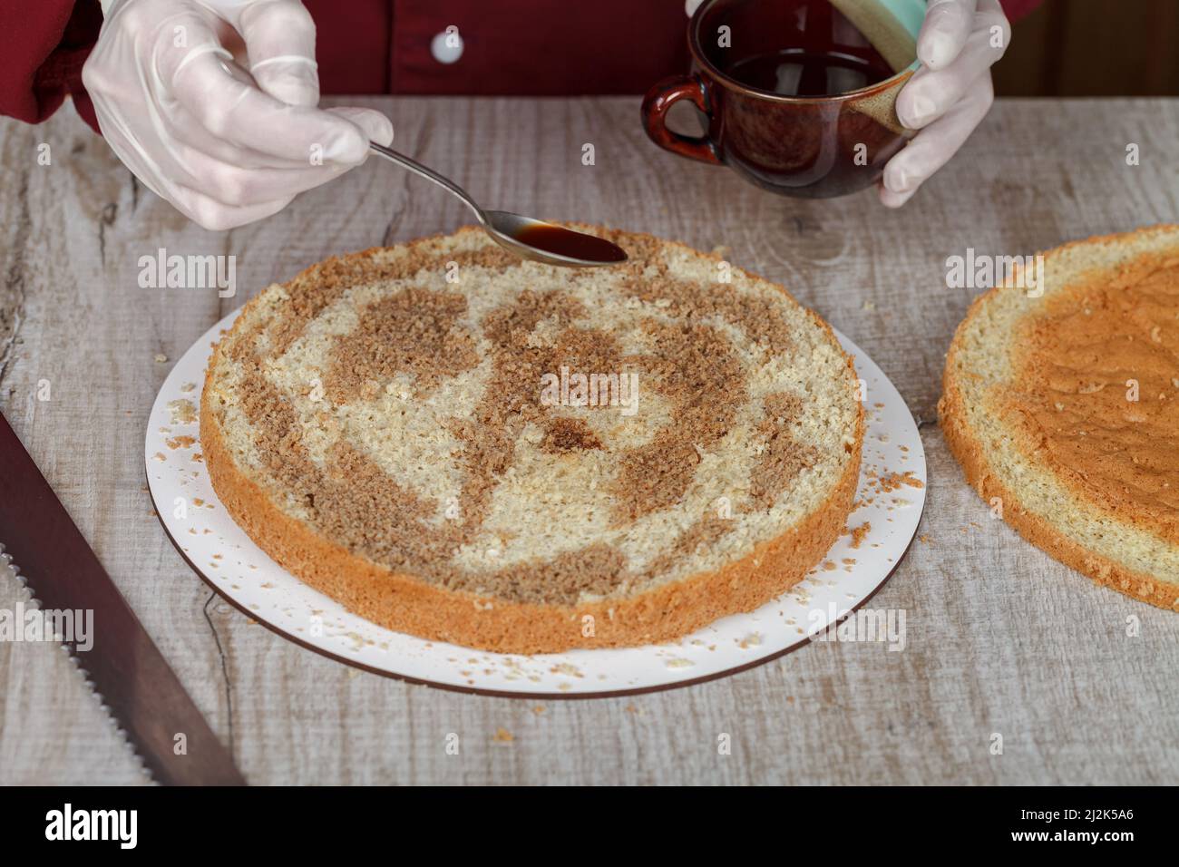 Il biscotto appena sfornato per tiramisù è impregnato di caffè espresso. Foto Stock