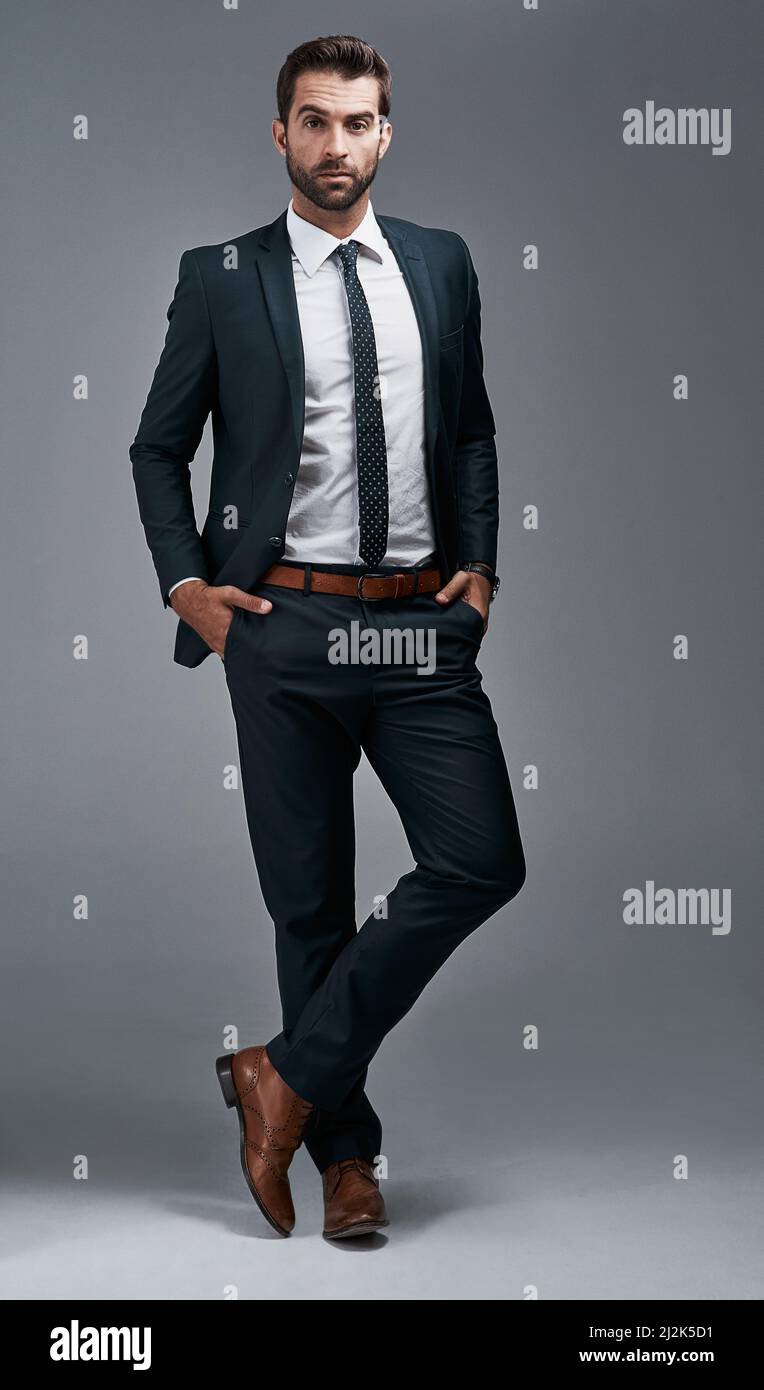 Guarda ogni parte l'uomo di successo. Ritratto di studio di un bel giovane uomo d'affari che si posa su uno sfondo grigio. Foto Stock