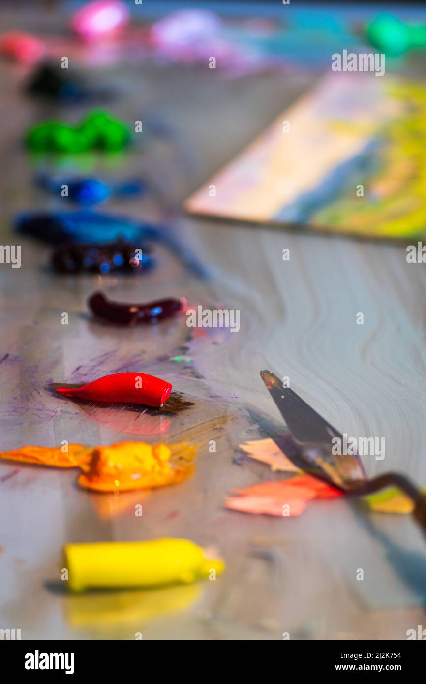 Vernici ad olio pronte per la miscelazione su una superficie di vetro con coltello a palette Foto Stock