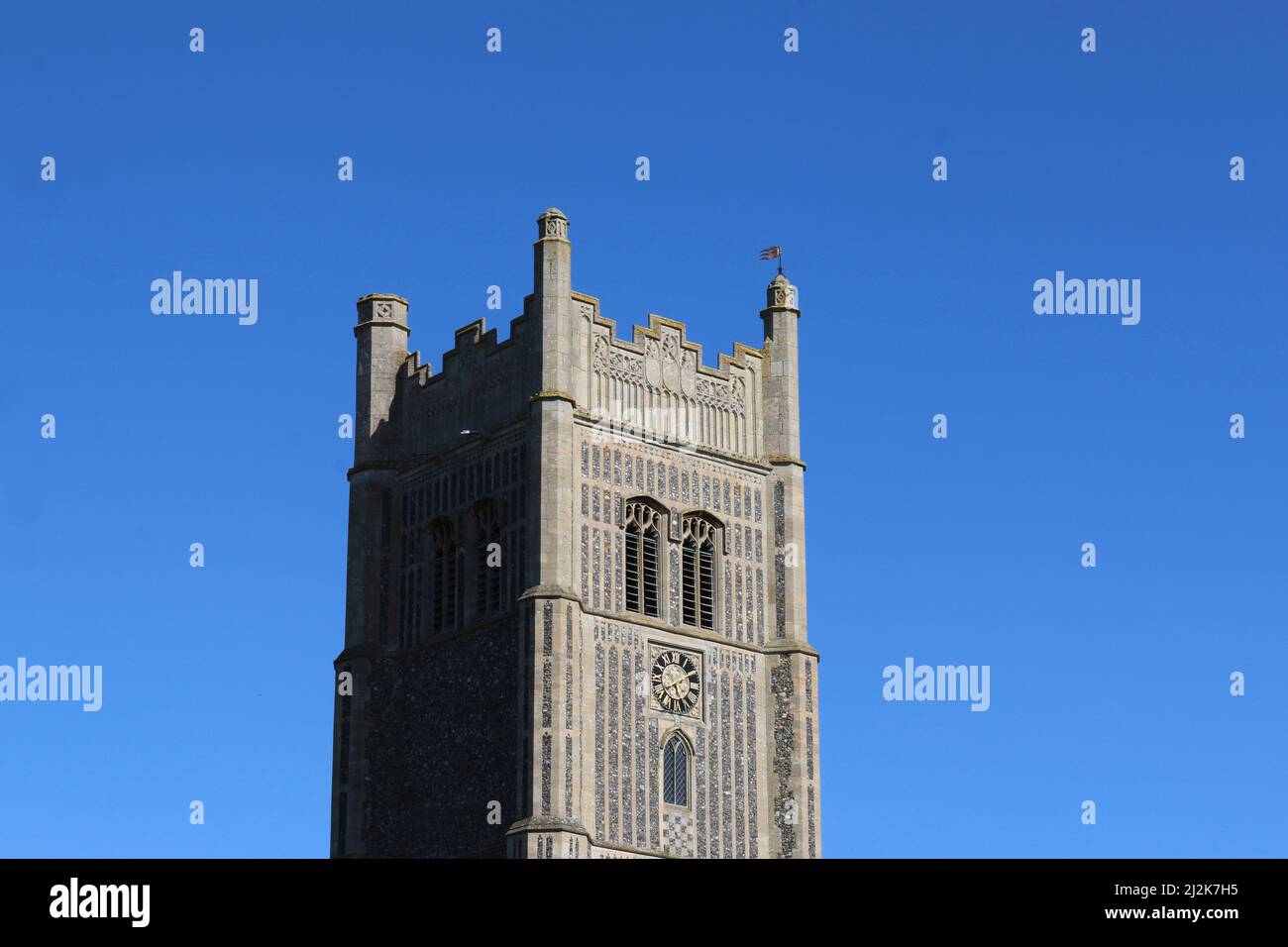 Torre Ovest della chiesa parrocchiale di San Pietro e San Paolo a Suffolk e cielo blu senza nuvole sullo sfondo. Foto Stock