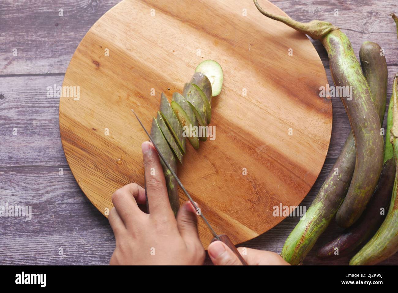 tagliando melanzane su un tagliere Foto Stock