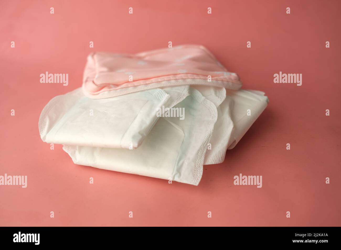 primo piano dell'imbottitura sanitaria su sfondo rosa Foto Stock