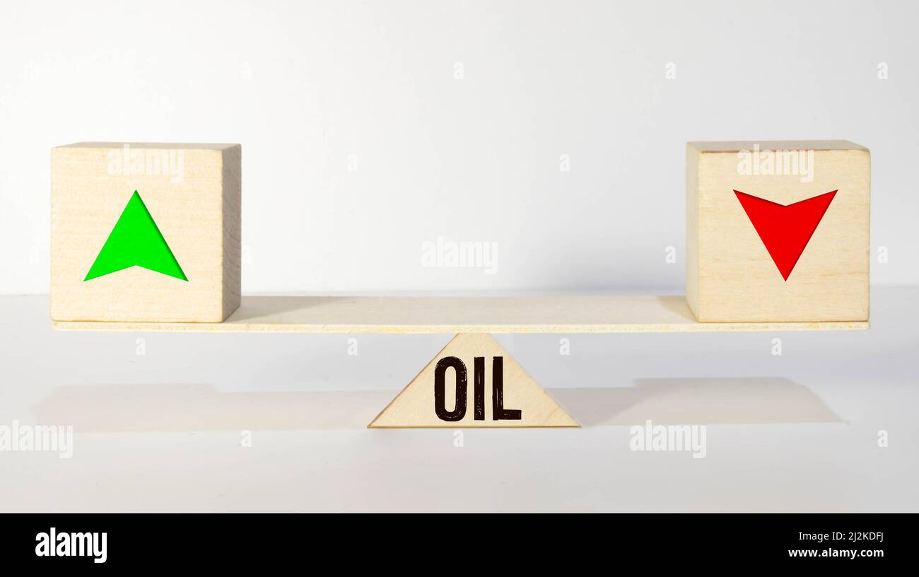Cubetti e dadi con olio e frecce su un giù su sfondo di legno. Foto Stock