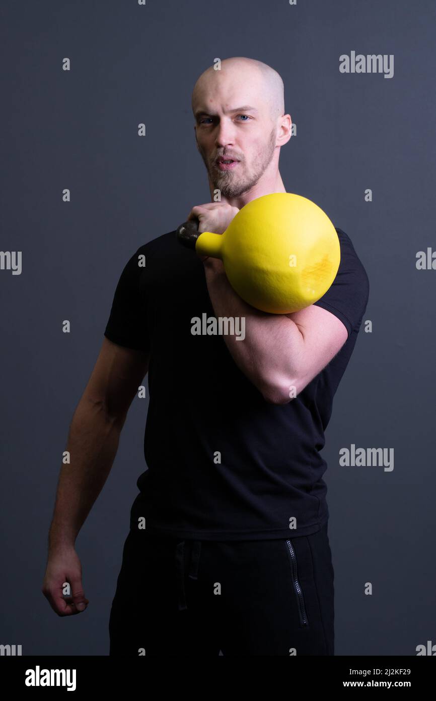 Ragazzo con una palestra gialla kettlebell anonima giovane forza, nel pomeriggio motivazione adolescente per gli uomini e abbigliamento sportivo da pavimento, vietnamita filippino. Ragazzo Foto Stock