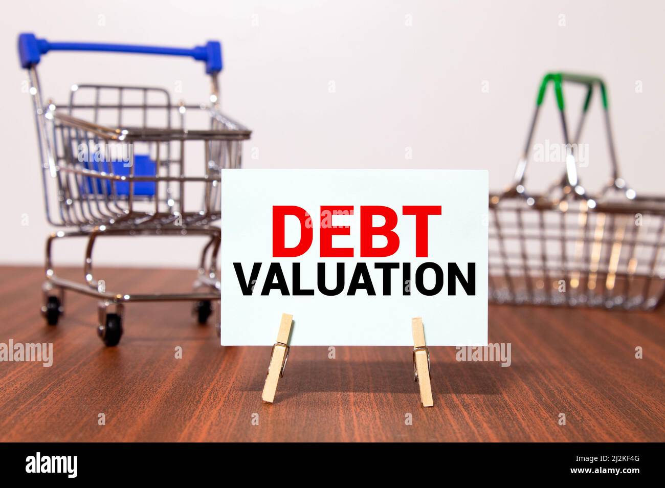 Parola scrittura testo debito Valuation. Concetto di business per il processo di determinazione del valore attuale di un bene carta matematica attaccato a un bastone e p Foto Stock