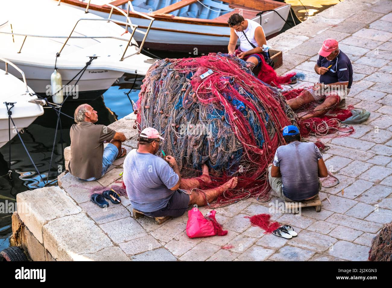 Italia Puglia. Gallipoli.Fishermen mend loro reti Foto Stock