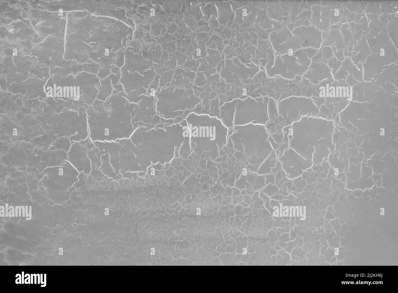 Vernice grigia sulla vecchia texture screpolata della superficie della parete incrinata sullo sfondo. Foto Stock