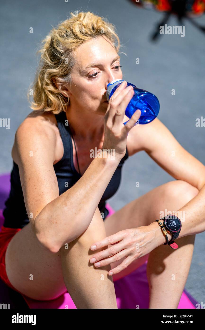 Vera giovane caucasica matura donna in uno sport indossare acqua potabile in palestra. Concetto di fitness. Foto Stock