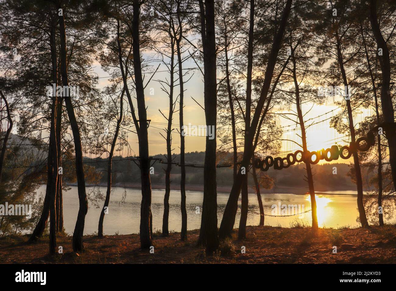 Magnifico tramonto, grande laghetto e riflessi luminosi in acqua. Cielo arancione e silhouette nere di alberi. La bellezza della natura in Turchia. Foto Stock