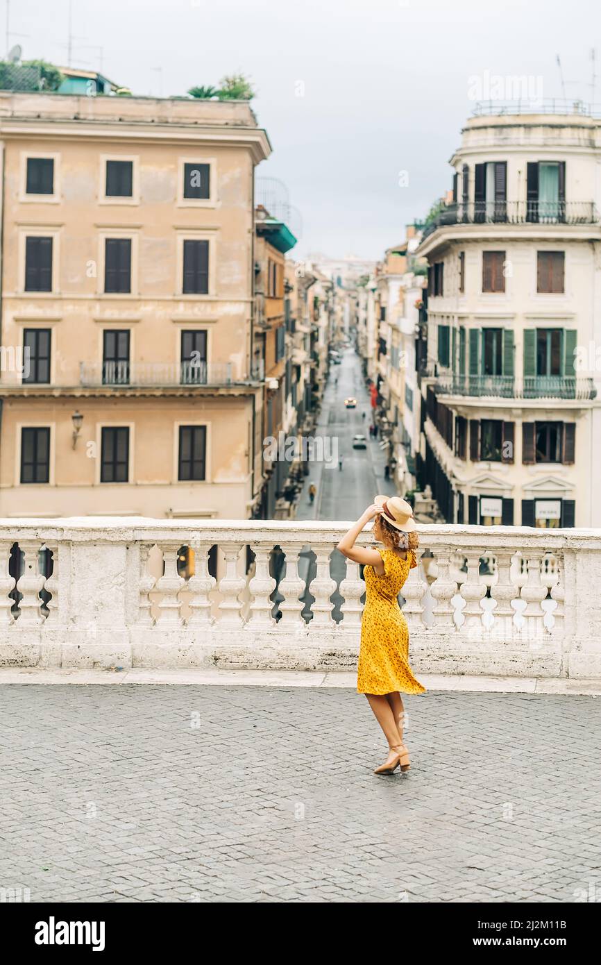 Ragazza allegra che indossa cappello e danza con vista su Roma. Concetto di viaggio estivo e turismo a Roma. Foto Stock