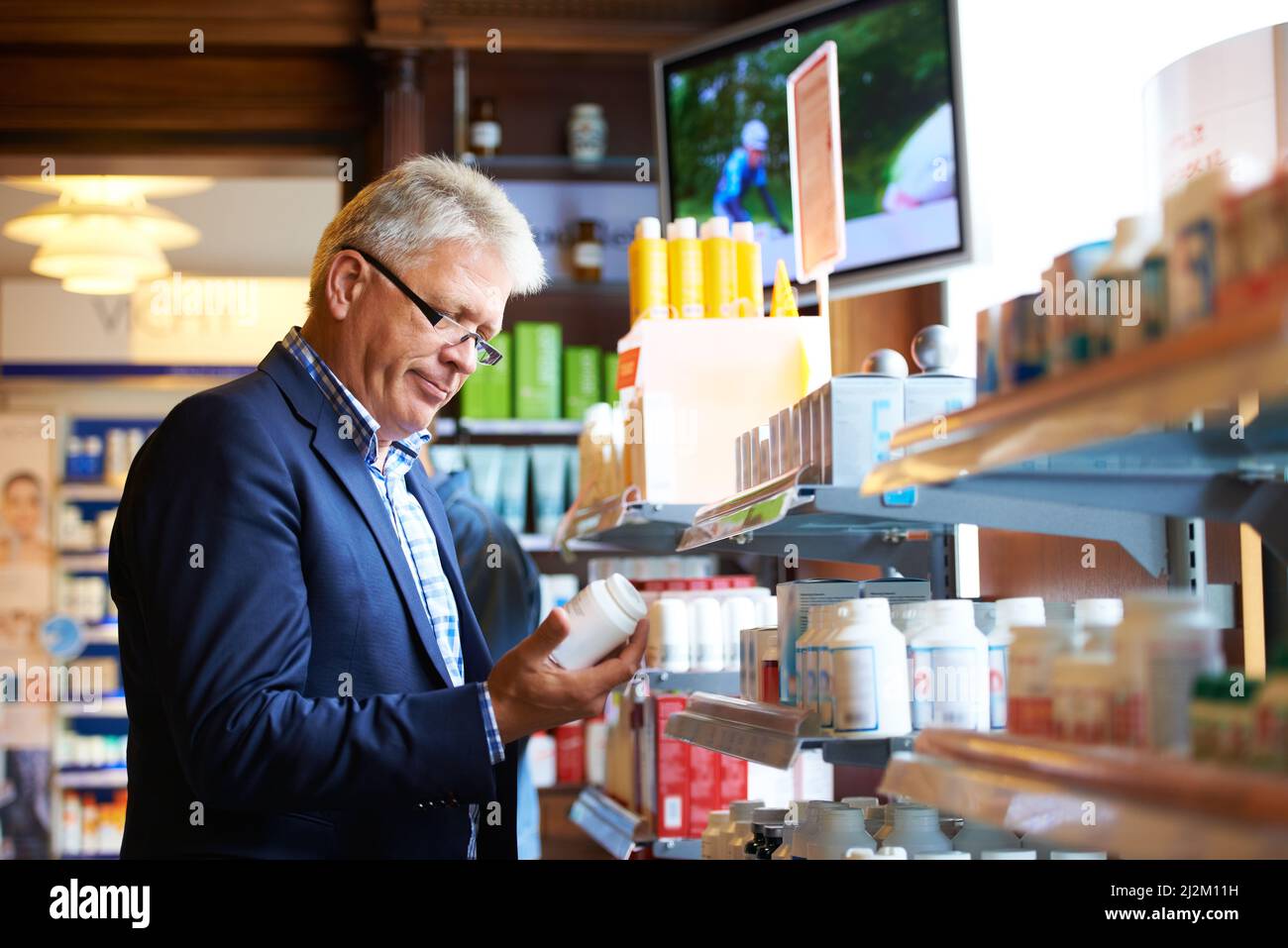 Devo fare scorta di questo farmaco. Shot di un uomo anziano in cerca di farmaci in una farmacia. Foto Stock