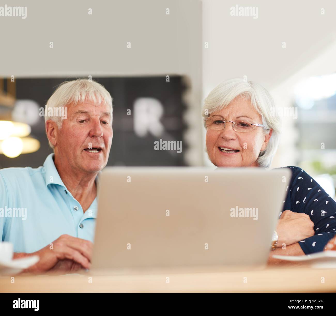 Possiamo utilizzare il wi-fi gratuito per fare qualsiasi cosa. Scatto di una coppia anziana che usa un notebook insieme. Foto Stock