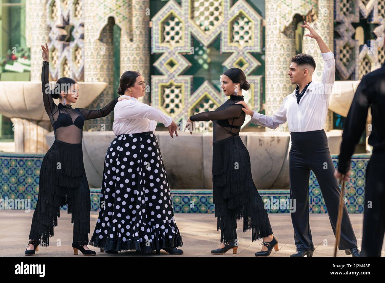 Maestro guarda un gruppo di alunni di flamenco che colpisce una posa con un arredamento arabo Foto Stock