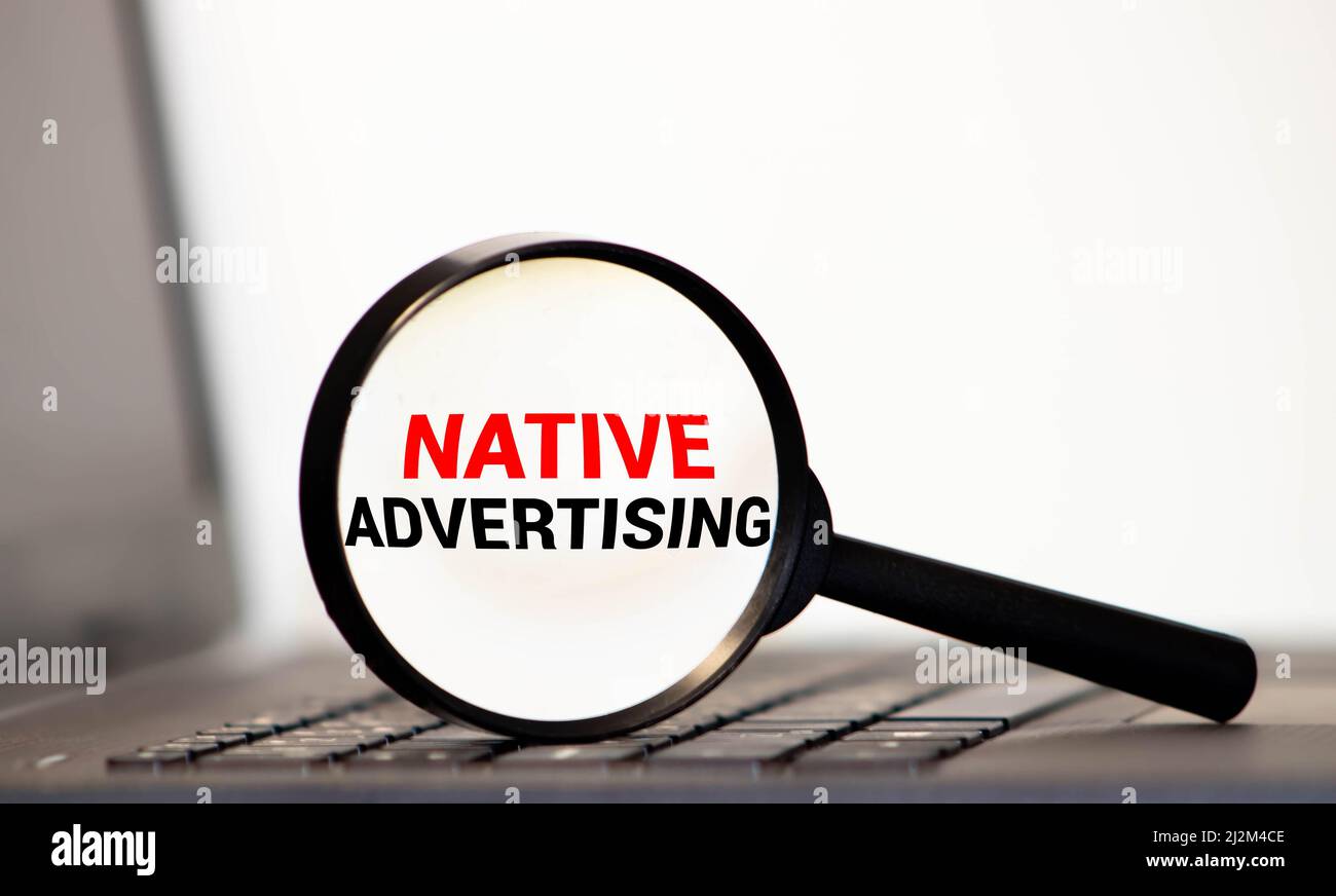 Lente d'ingrandimento con la parola pubblicità nativa. Foto Stock