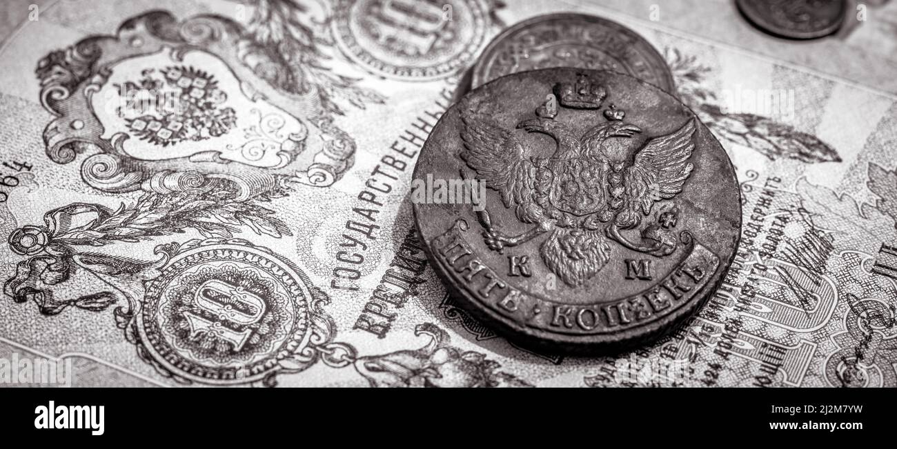 Denaro dell'Impero Russo, vecchie monete e banconote. Monete di rame antico e moneta di carta con stemma imperiale della Russia. Concetto di raro d'annata Foto Stock