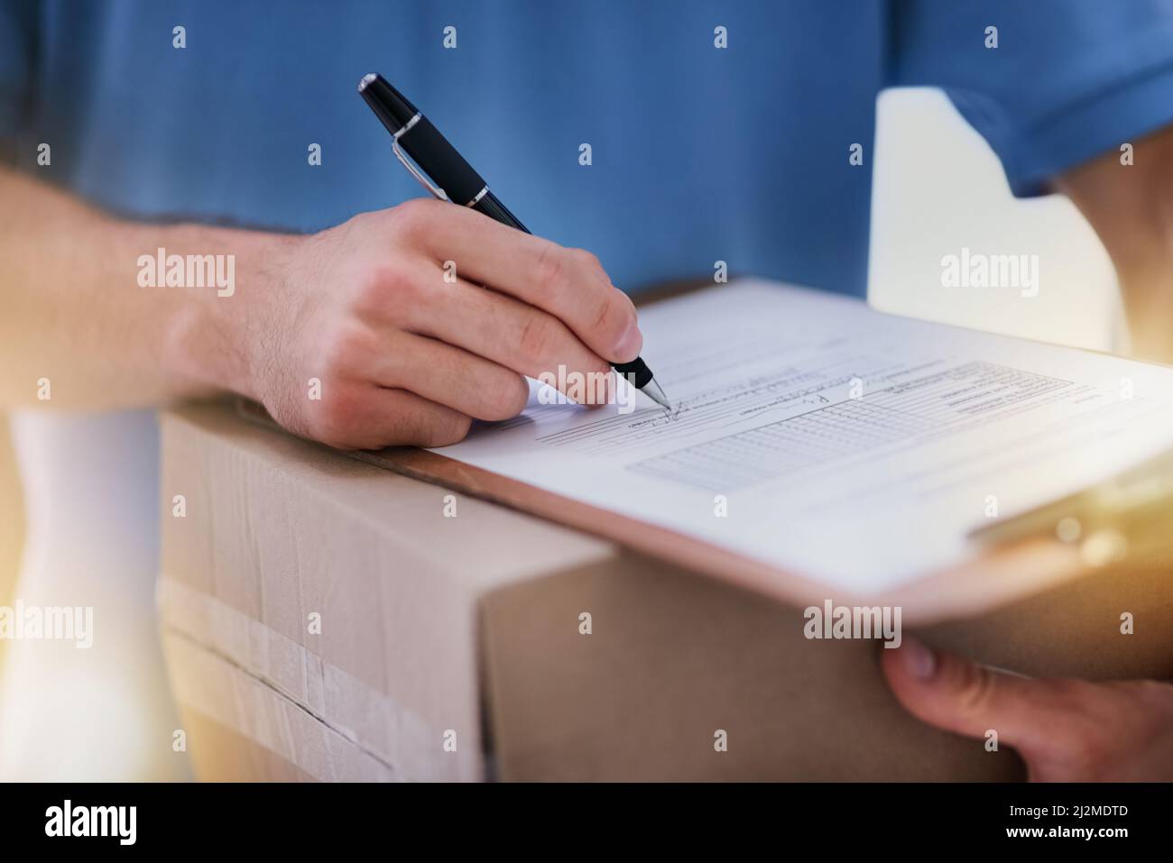 Mantenere intatto il percorso della carta. Shot di un addetto alla consegna non identificabile che compila documenti cartacei mentre è in consegna. Foto Stock