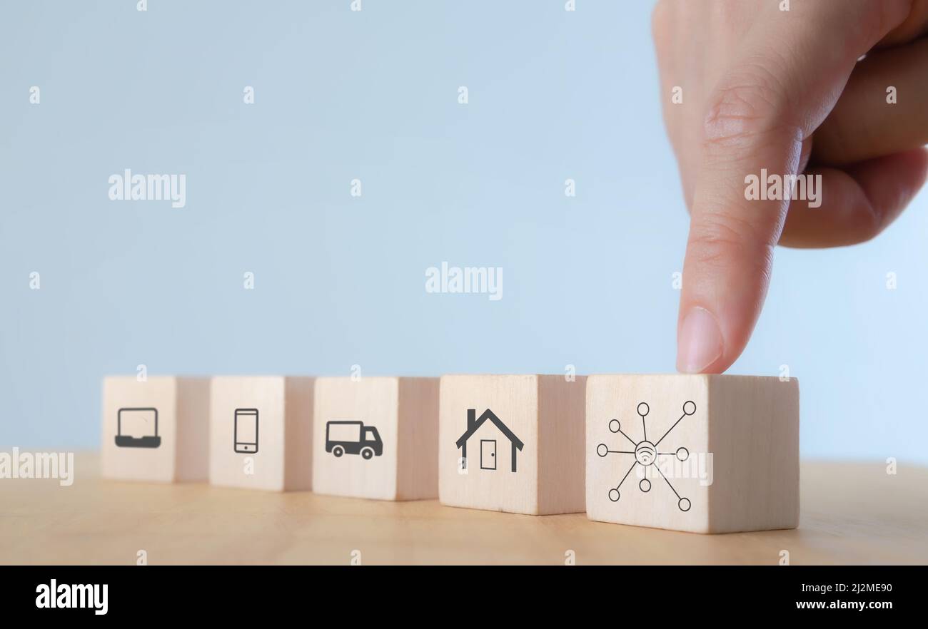 Concetto di dispositivo di connettività Internet delle cose (IOT) Everything. Tecnologia digitale per una vita migliore.cubi in legno con icona IOT; computer, telefono cellulare, auto Foto Stock