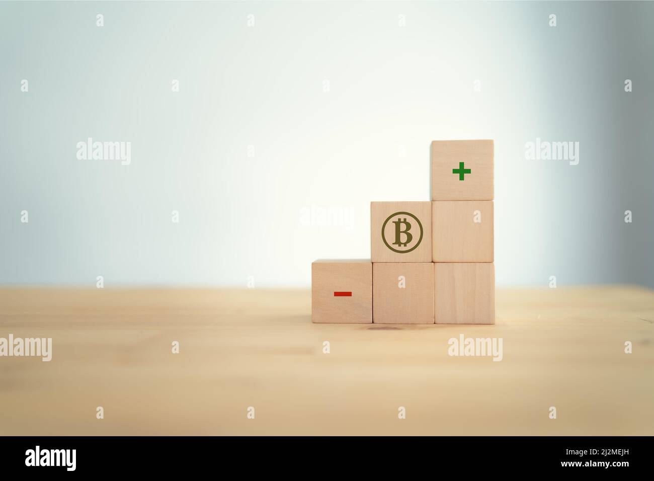 Bitcoin cripto valuta; concetto di investimento finanziario. Concetto di profitti e perdite. Bitcoin, positivo e negativo che simboleggia su cubi di legno che il v Foto Stock