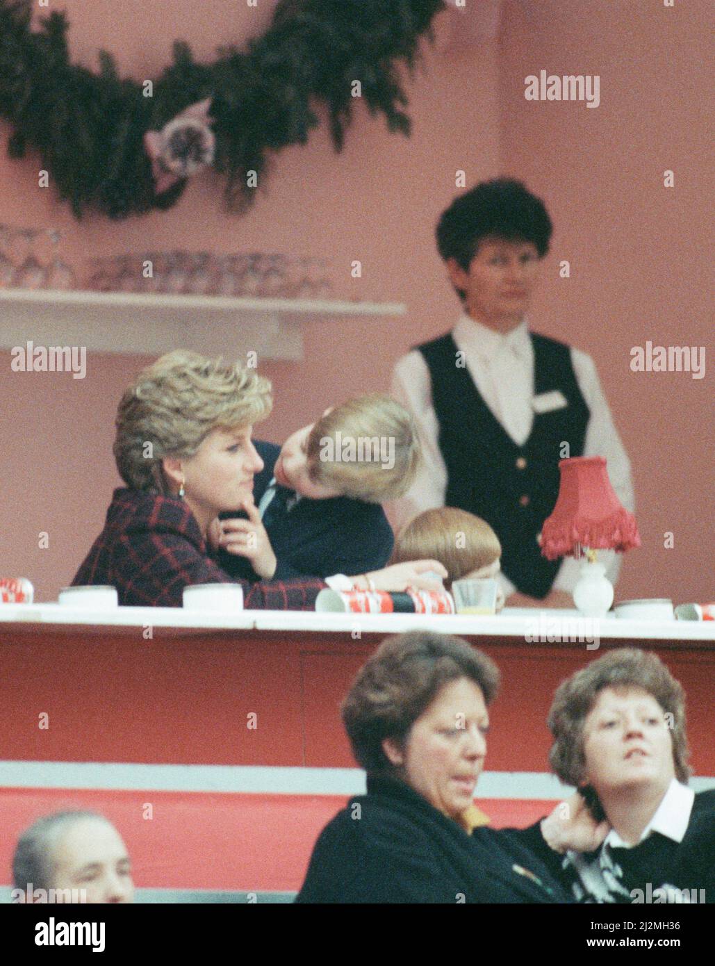 S.A.R. la Principessa Diana, la Principessa del Galles, con i suoi figli il Principe William e il Principe Harry. Sono raffigurati all'International Horse Show di Olympia, West London. Il principe William baciò e coccolò sua madre, mostrando quanto sia contento di tornare con lei dopo essersi sviato dalla scuola di preparazione di Ludgrove la domenica. Foto scattata il 17th dicembre 1990 Foto Stock