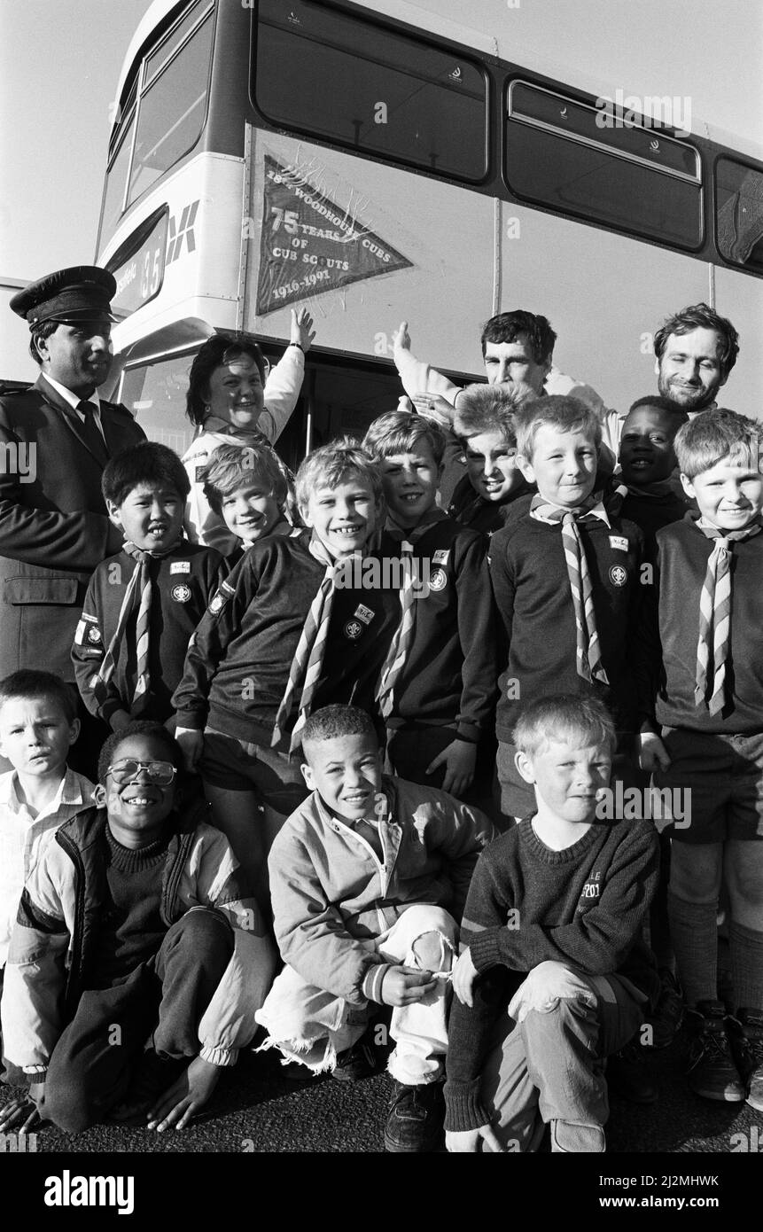 Questi Huddersfield Cubs hanno fatto in modo che la loro bandiera commemorativa stava andando luoghi volandolo in alto su su un autobus a due piani. Il pacchetto Woodhouse ha richiesto una sfida per progettare e fare la propria bandiera per celebrare il 75th anniversario di Cubs in tutto il mondo - poi volare da un luogo insolito. Gareth Firth, di otto anni, ha presentato il design vincente nella forma e nei colori di un nickerchier, e gli è stato presentato un orologio dal suo pacchetto. Con l'autobus e la bandiera sono raffigurati i Cubs e Yorkshire Rider Controller Younus Mumtaz. 12th giugno 1991. Foto Stock