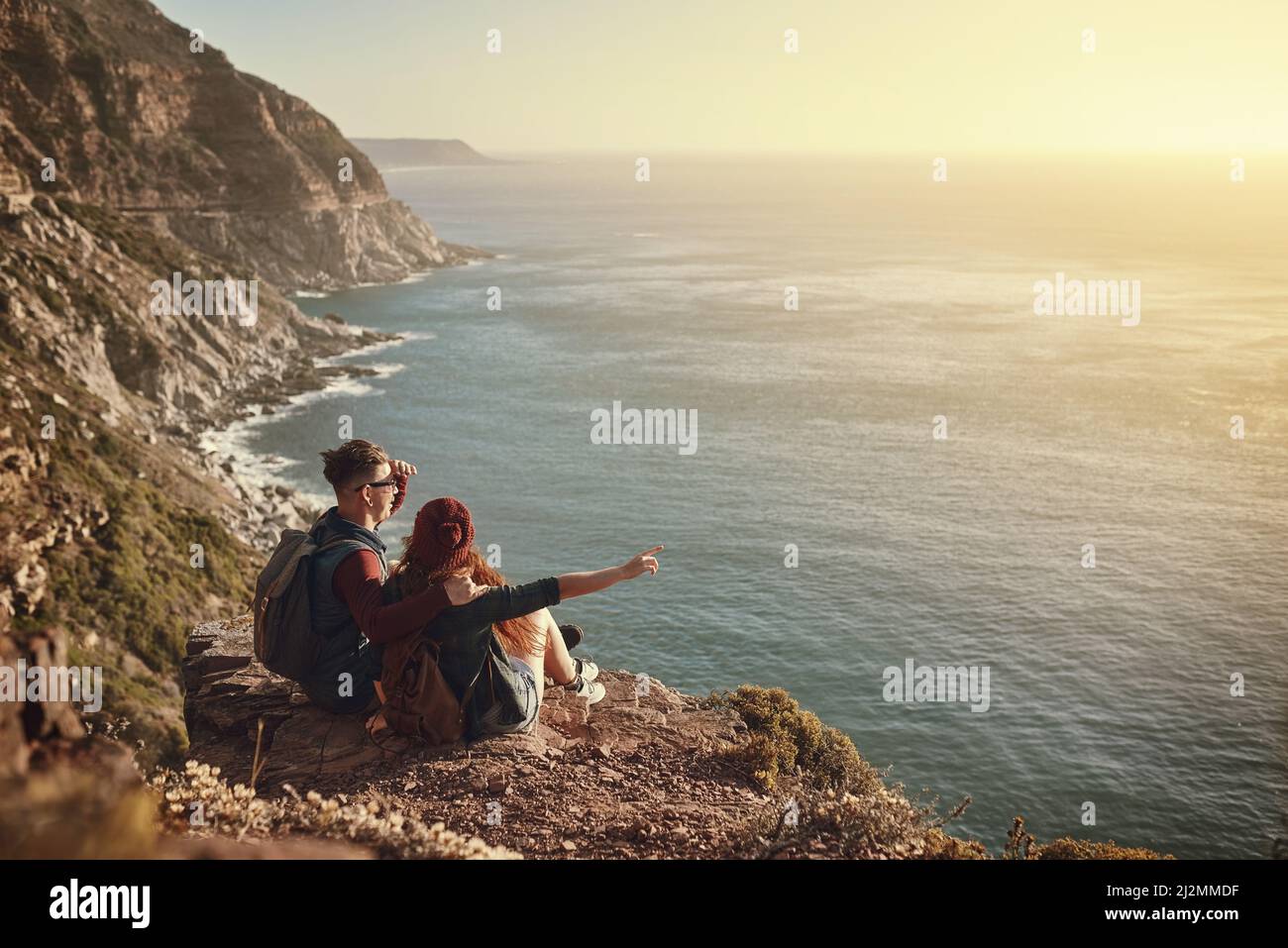 Dai un'occhiata qui. Scatto ad angolo alto di una giovane coppia affettuosa che prende in vista da una cima di montagna. Foto Stock