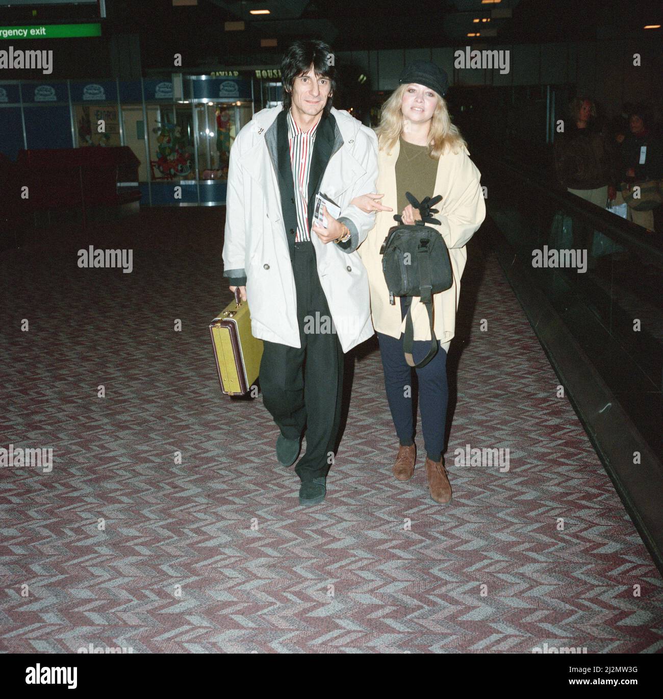 Ronnie Wood e sua moglie Jo all'aeroporto di Heathrow. 28th febbraio 1991. Foto Stock