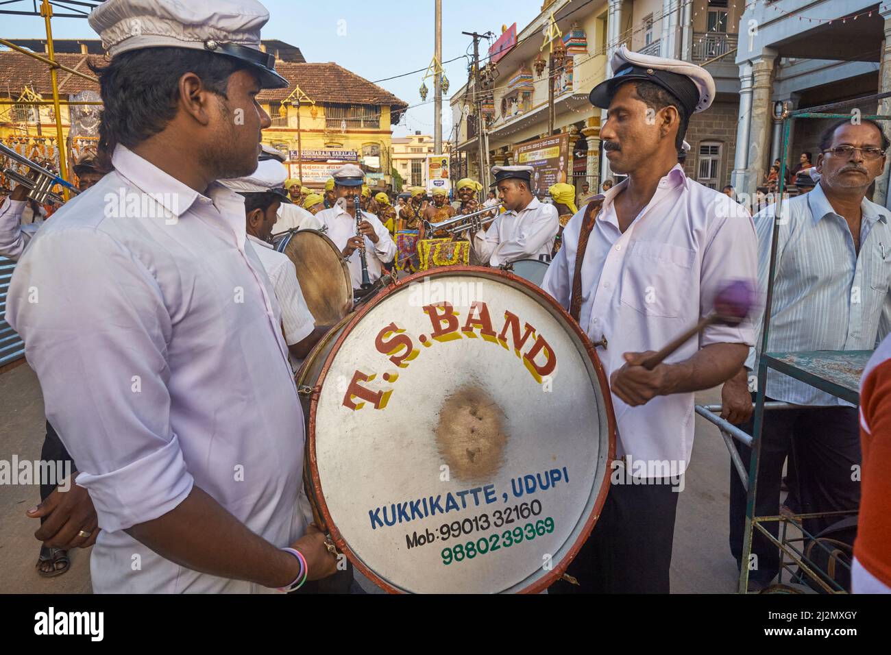 Una festa e una banda di nozze con tamburo e trombe durante una festa marciando intorno al Tempio Balkrishna a Udupi (Udipi), Karnataka, India del Sud Foto Stock