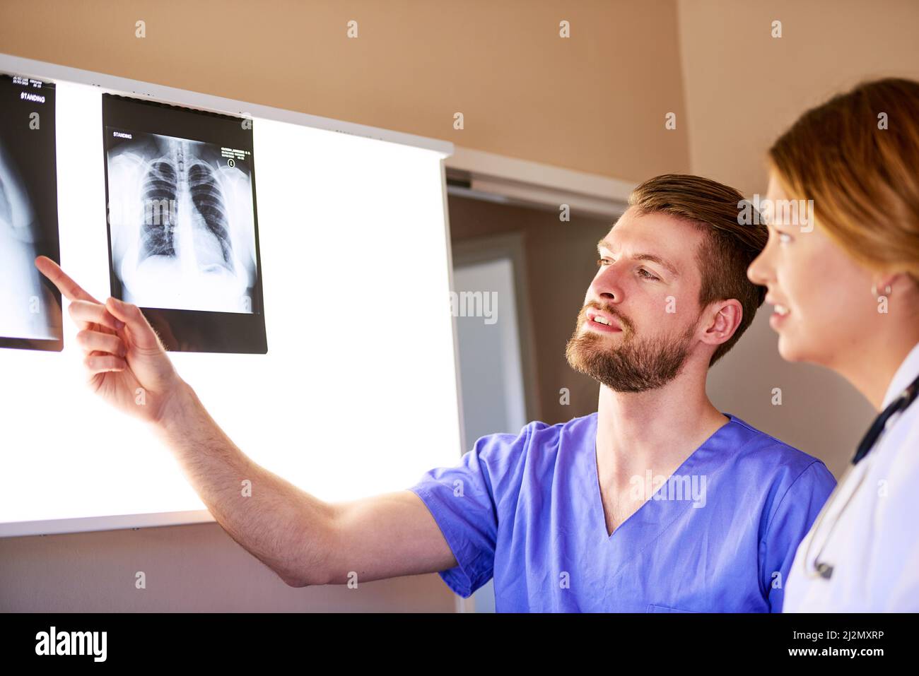 Cosa ne pensate di questo settore. Shot di un medico giovane e di un infermiere maschio che esaminano una radiografia insieme. Foto Stock