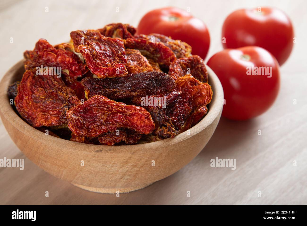 Pomodori freschi e pomodori secchi insieme su sfondo di legno Foto Stock