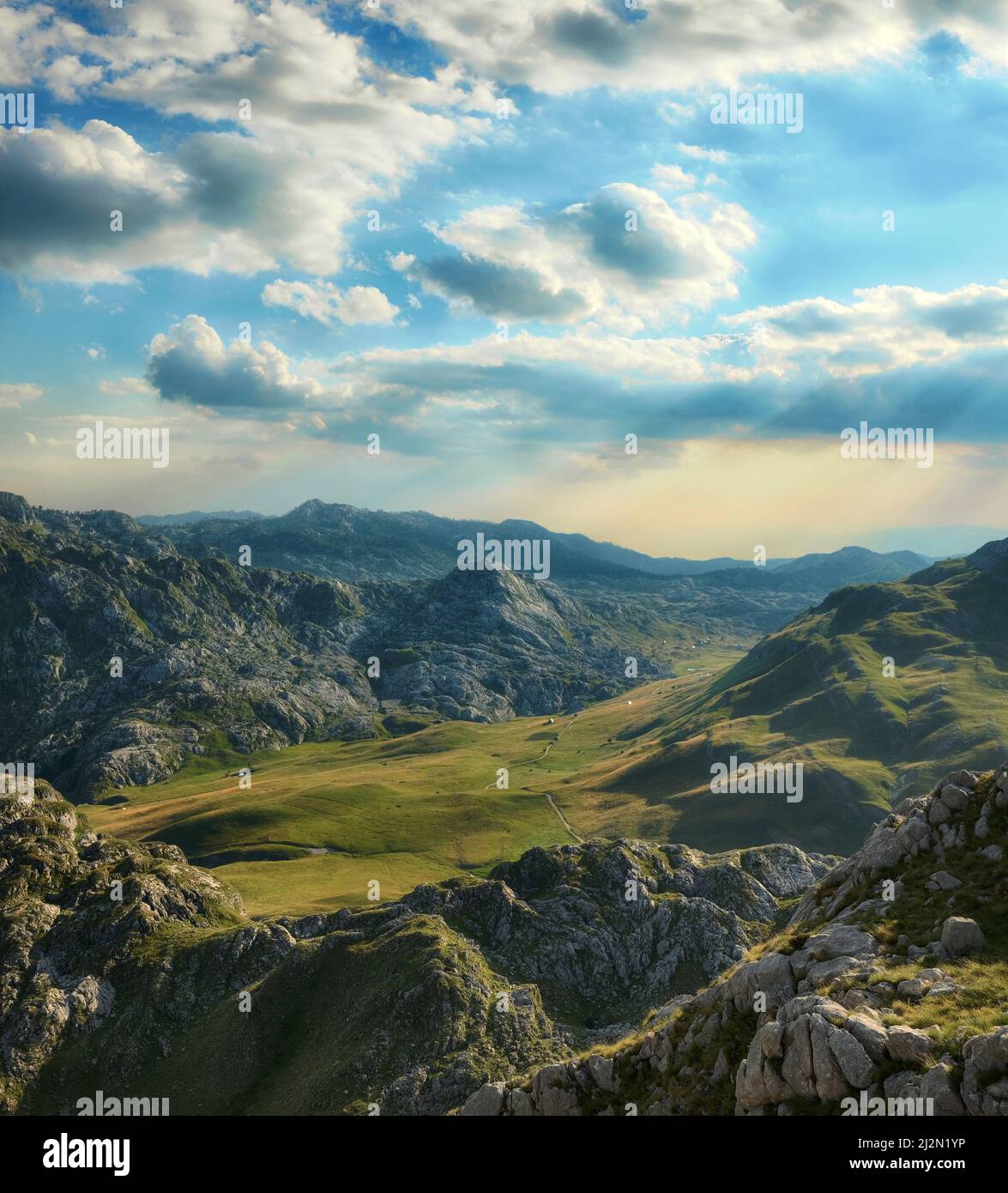Paesaggio nuvoloso sul prato verde tra la montagna del Montenegro Foto Stock