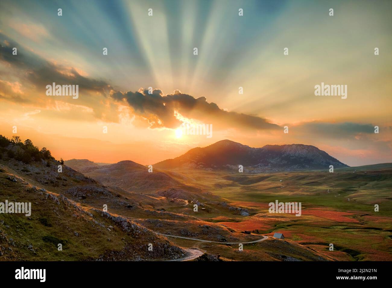 Tramonto colorato con nuvole e raggi di luce sull'Altopiano Lukavica, Montenegro Foto Stock