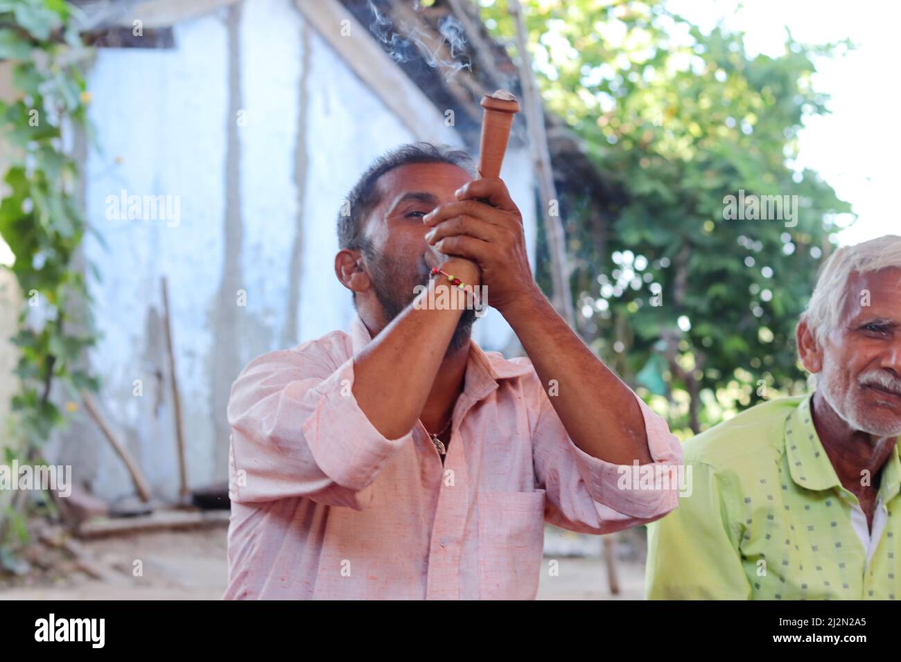 Pali Rajasthan , India - 23 ottobre 2021. Primo piano di un uomo indiano adulto che fuma un piccolo hookah (chilam) Foto Stock