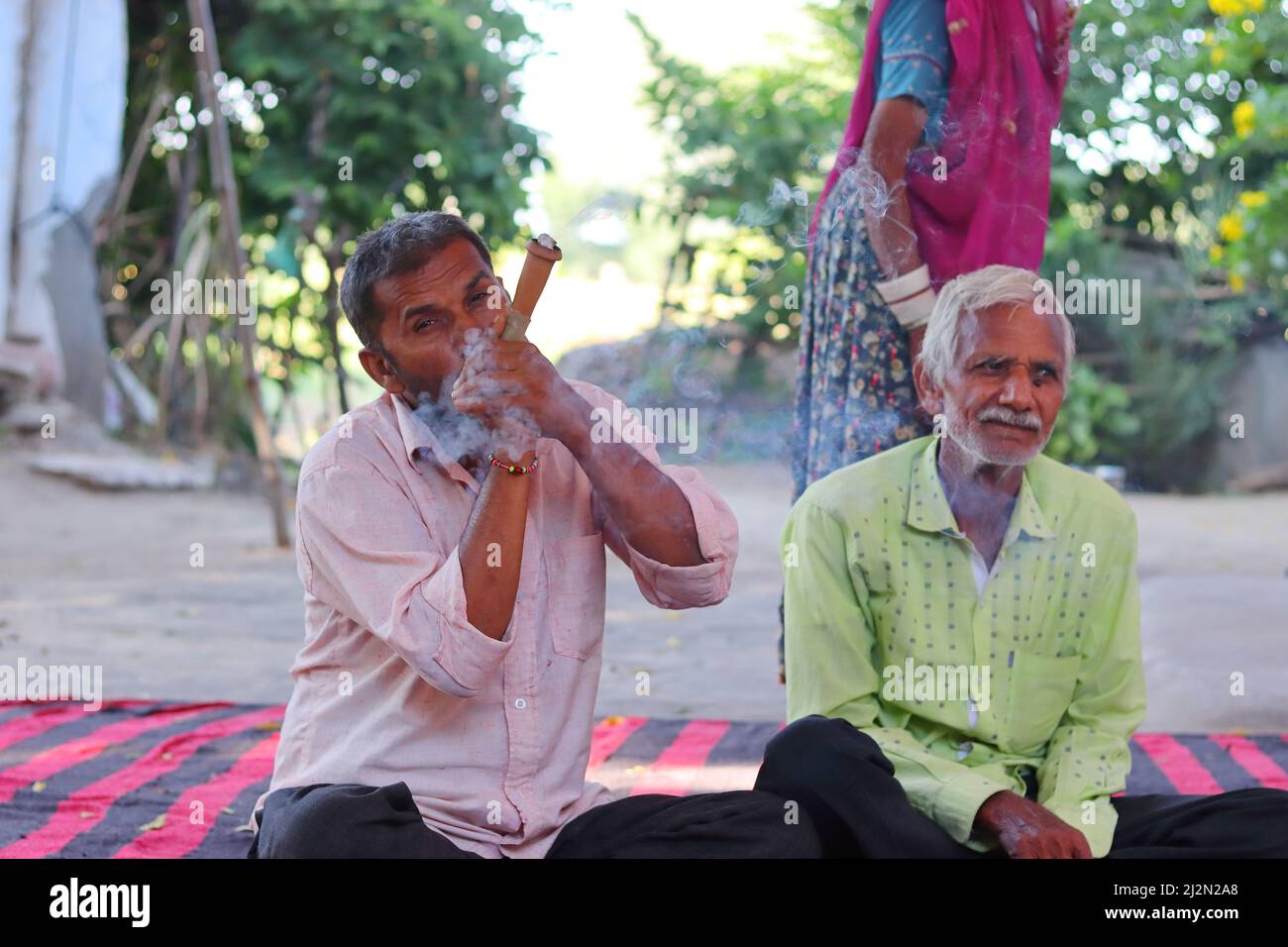 Pali Rajasthan , India - 23 ottobre 2021. Foto ravvicinata di un uomo indiano adulto che fuma un piccolo hookah (chilam), villaggio indiano tradizionale Foto Stock