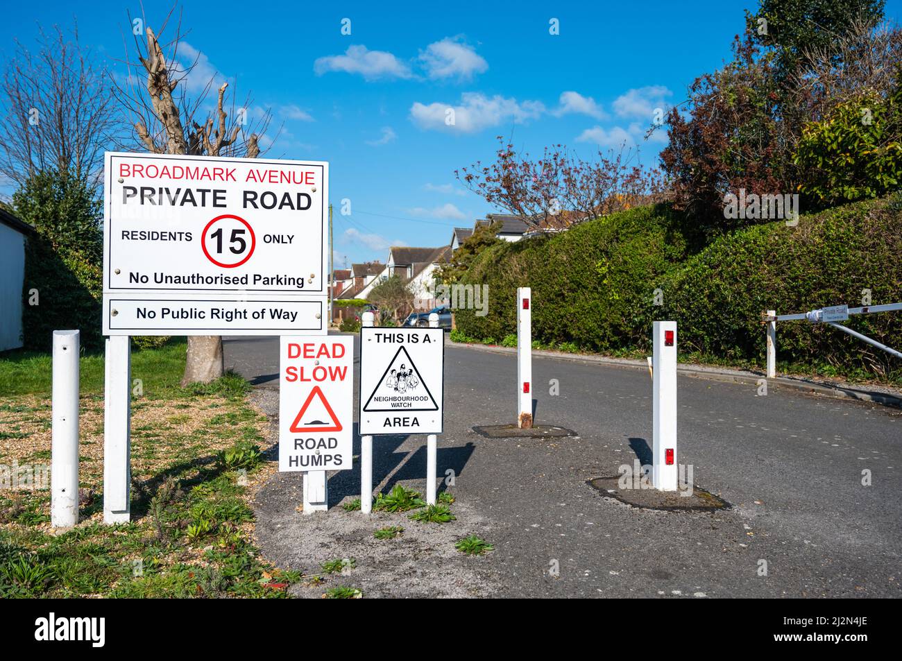 Entrata con cancello con 15MPH segnale di limite di velocità e segnale di rallentamento morto verso una strada privata a Broadmark Avenue, Rustington, West Sussex, Inghilterra, Regno Unito. Foto Stock