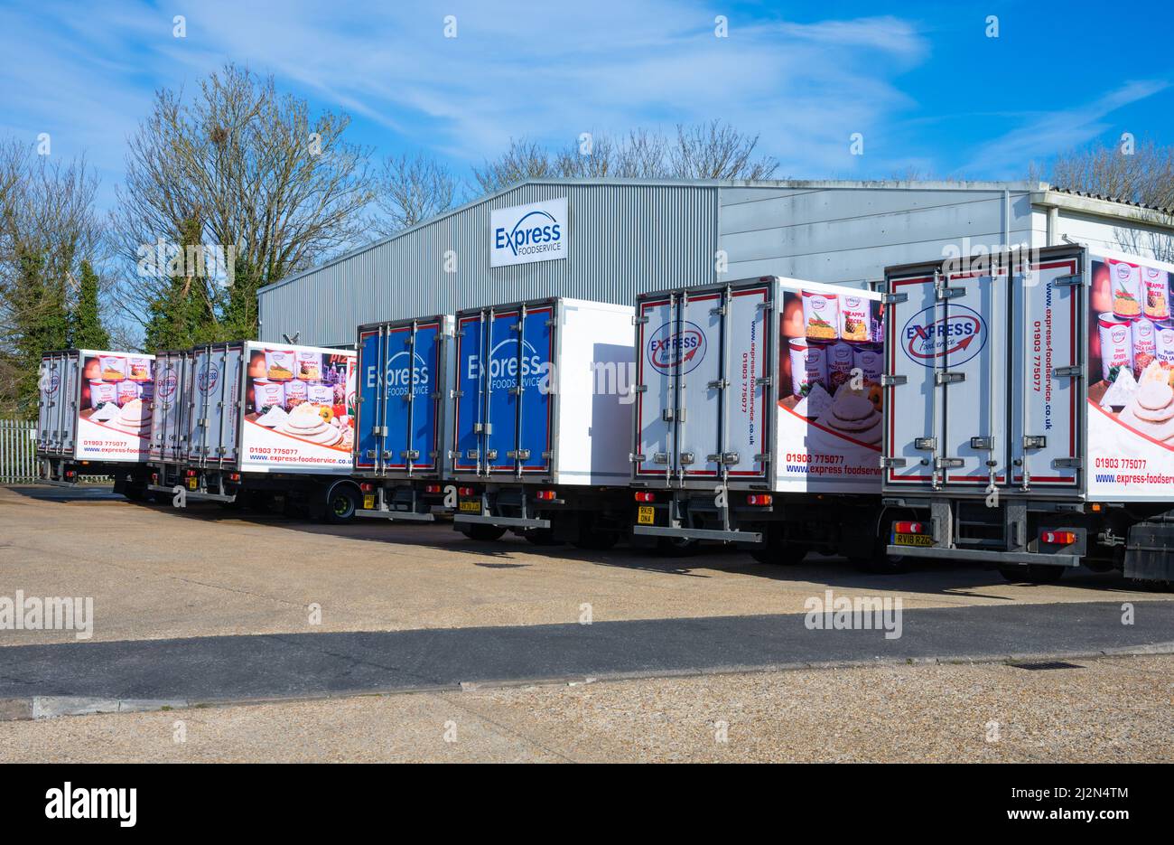 Camion di trasporto o autocarri parcheggiati in una linea in un deposito Express Food Service in una proprietà industriale a Rustington, West Sussex, Inghilterra, Regno Unito. Foto Stock