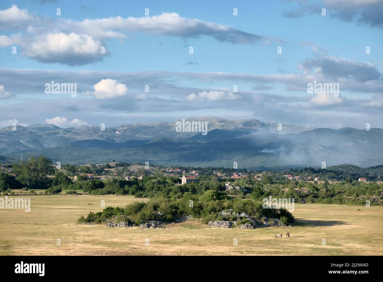 Paesaggio nuvoloso su paesaggio di campagna con piccola cappella intorno al Lago di Slano, Montenegro Foto Stock