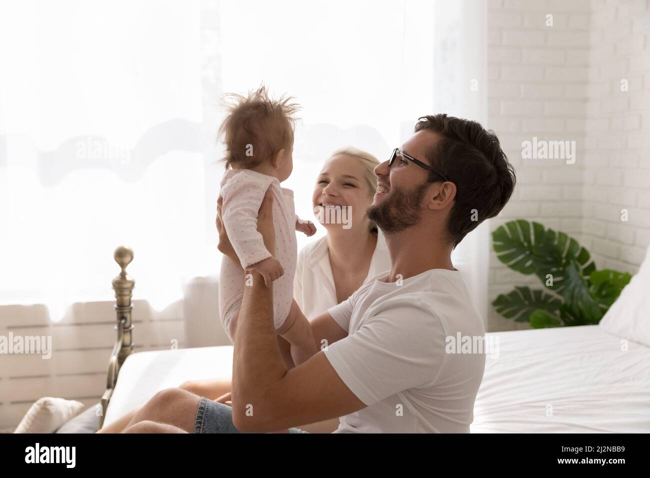 Coppia felice di giovani genitori e bambino che si divertono Foto Stock