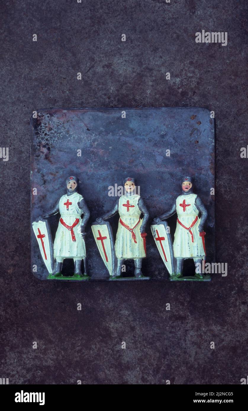 Tre modelli d'epoca in piombo di Cavaliere Crociato Inglese in armatura con scudo bianco con croce cristiana rossa Foto Stock