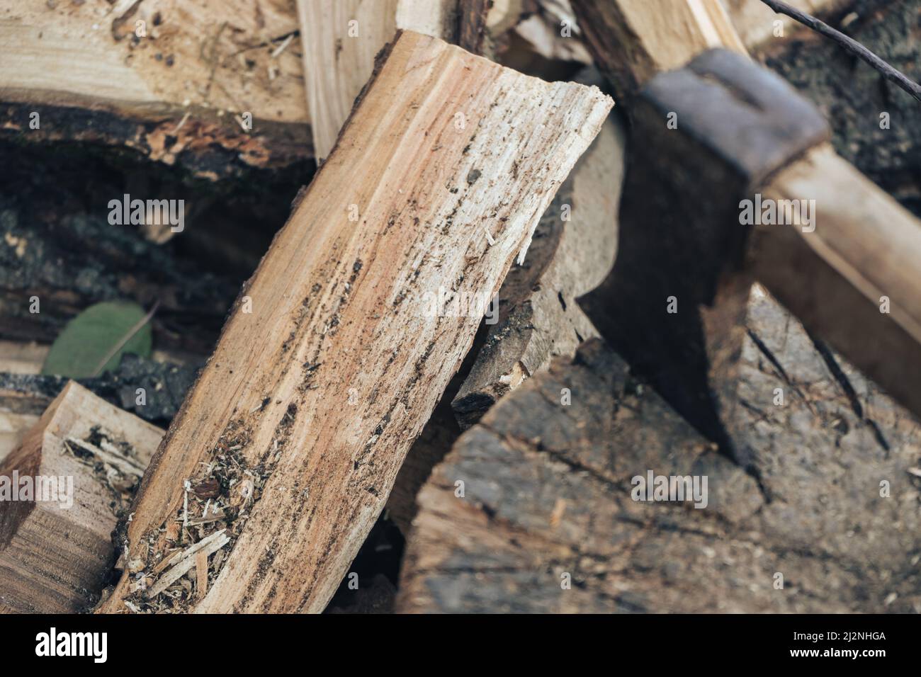 Bella una vecchia ascia con un manico di legno si trova su una pila di legna da ardere, vista dall'alto da vicino Foto Stock