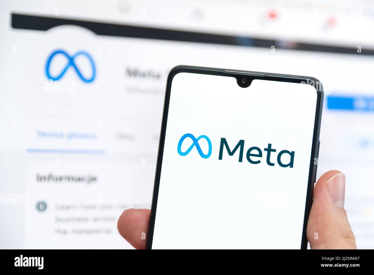 Wroclaw, Polonia - Apr 01, 2022: Facebook cambia il nome della sua azienda in Meta. Meta su uno smartphone e logo Facebook sullo sfondo Foto Stock