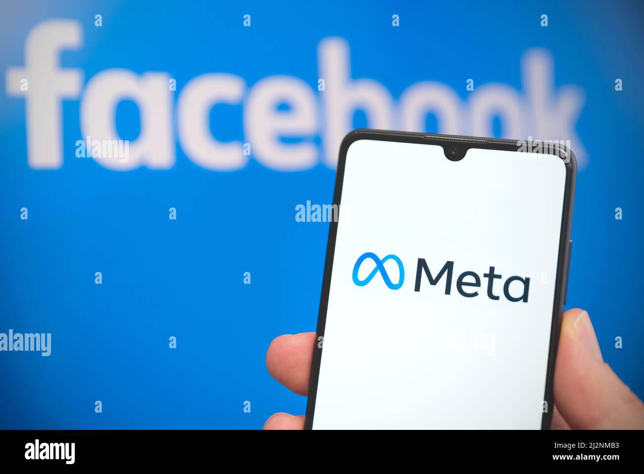 Wroclaw, Polonia - Apr 01, 2022: Facebook cambia il nome della sua azienda in Meta. Meta su uno smartphone e logo Facebook sullo sfondo Foto Stock