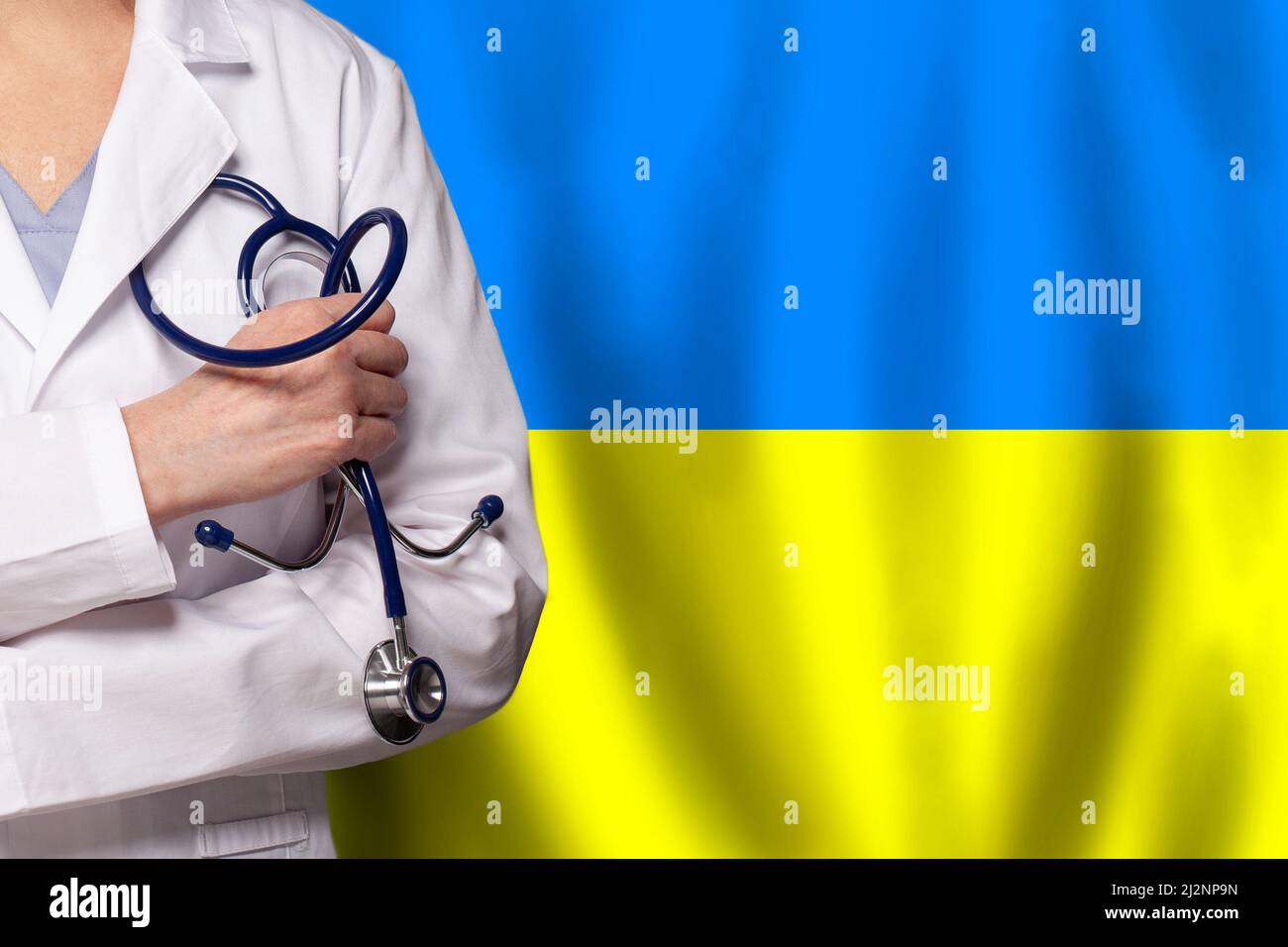 Salvare e aiutare il concetto Ucraina. Medico con stetoscopio in mano su sfondo bandiera ucraino Foto Stock