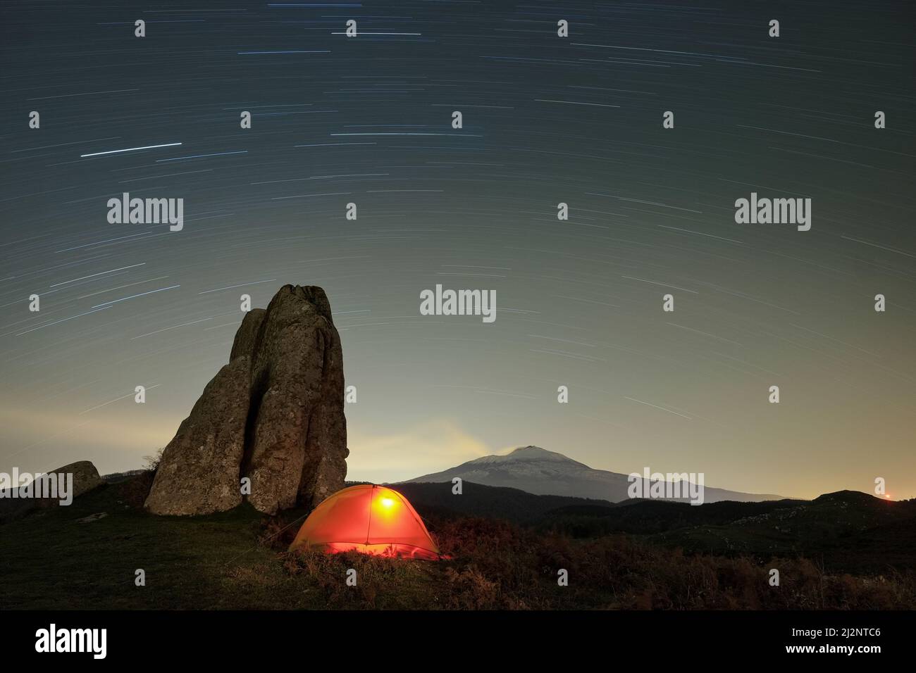 Sentieri stellari su tenda illuminante e megalite dell'Altopiano di Argimusco, Sicilia Foto Stock