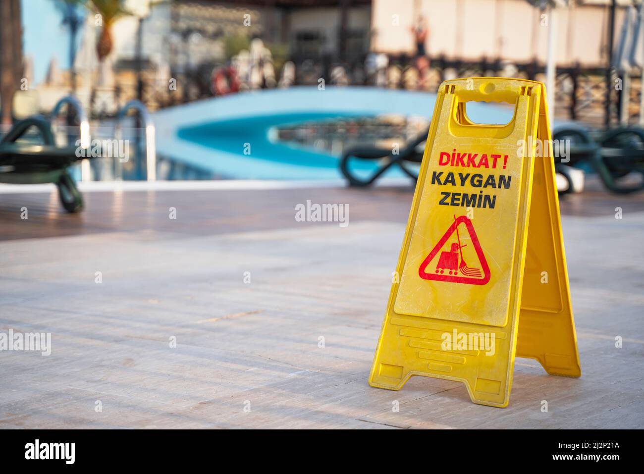 attenzione: cartello con il pavimento bagnato vicino alla piscina Foto Stock