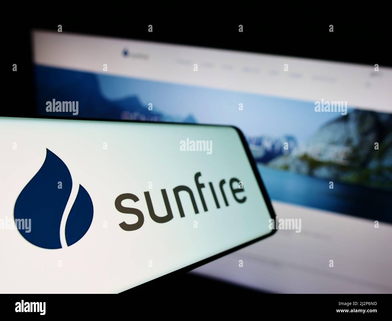 Telefono cellulare con logo della società tedesca di energia rinnovabile Sunfire GmbH sullo schermo di fronte al sito web aziendale. Mettere a fuoco sulla sinistra del display del telefono. Foto Stock