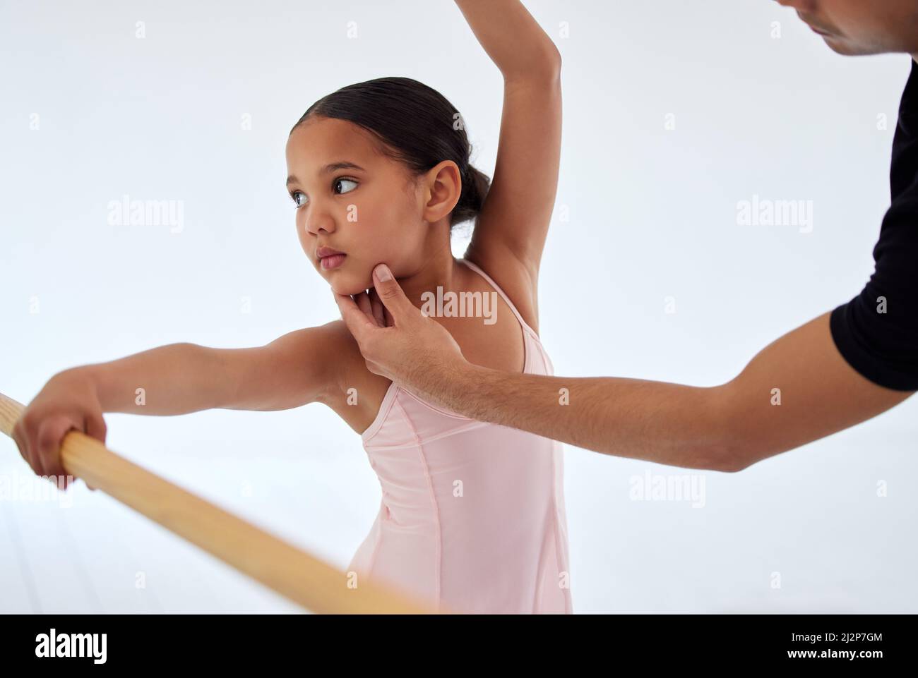 Guarda in questo modo. Primo piano di un insegnante di balletto che assiste uno studente con la sua posizione in uno studio di danza. Foto Stock