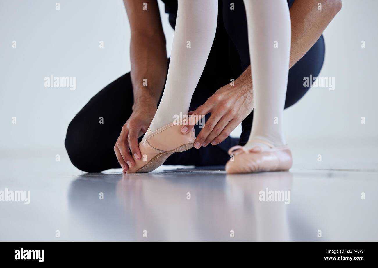 Imparare i passi uno alla volta. Primo piano di un insegnante di balletto che assiste uno studente con la sua posizione in uno studio di danza. Foto Stock