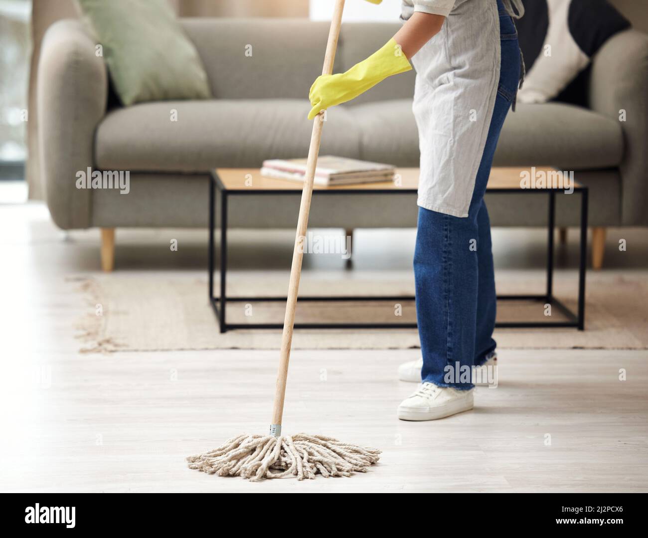 Non sempre nell'umore. Scatto di una donna irriconoscibile che mopping i pavimenti in casa. Foto Stock