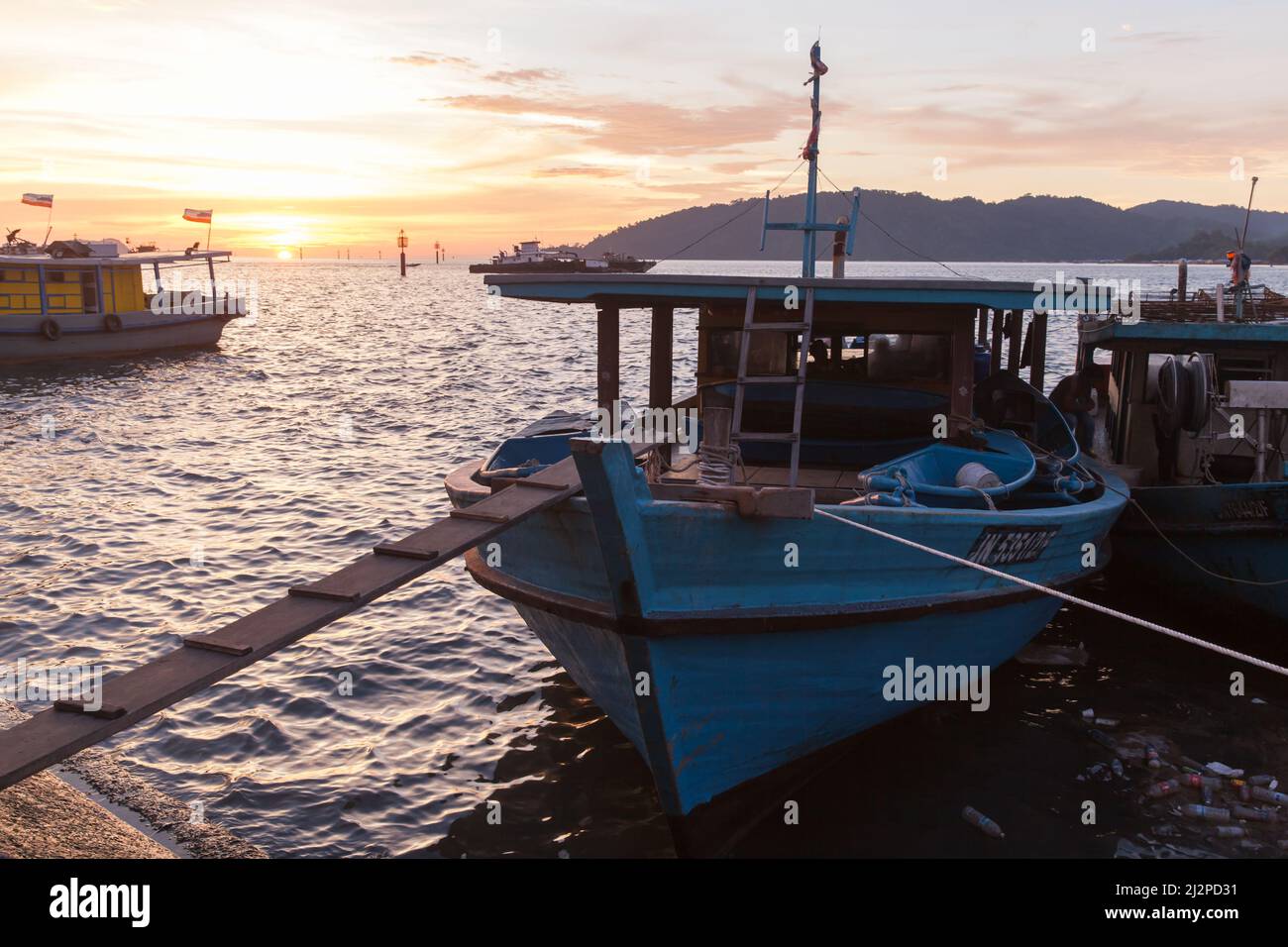 Kota Kinabalu, Malesia - 23 marzo 2019: Barche da pesca ormeggiate vicino al mercato del pesce KK al tramonto Foto Stock